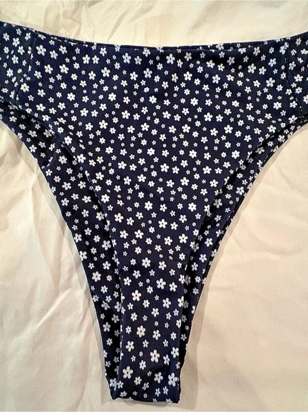 Patterned navy blue bikini bottoms with a white floral print.